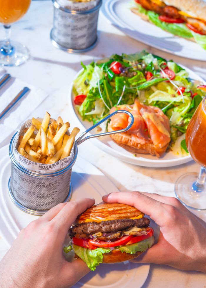 A mouthwatering gourmet burger with fries and salad, perfect for a delicious meal.